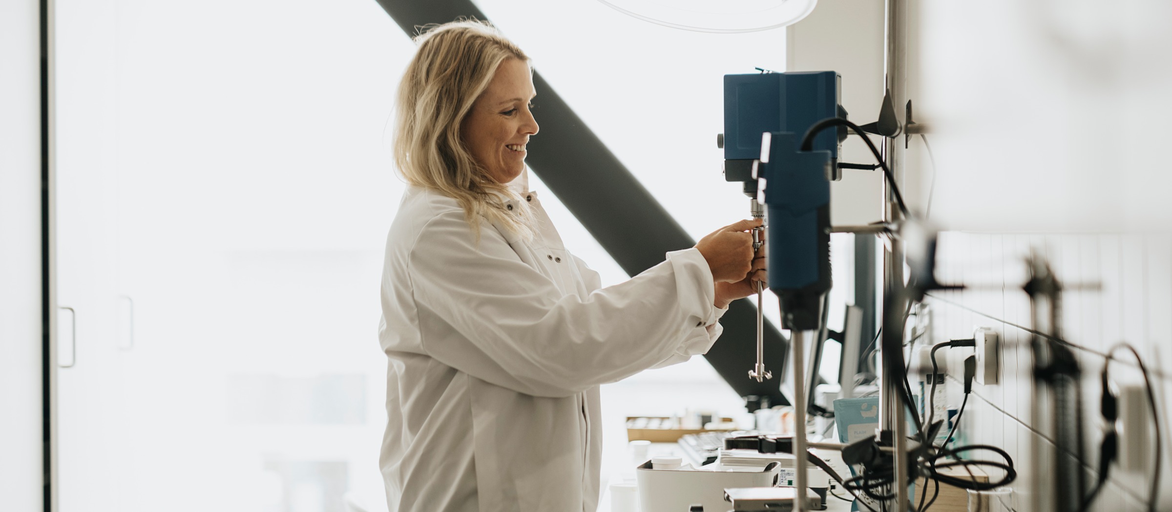 På våning 2 finns AAK:s andra lokal, 150 kvadratmeter som bland annat rymmer ett laboratorium där man utför olika tester. Laboratorium med kvinna i vit rock.